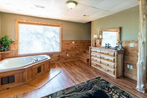 uma grande casa de banho com uma banheira e uma janela em Alpine Rose Beautiful Cabin Hot Tub Mountain Views em Sevierville
