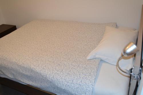 a bedroom with a bed with a white pillow at Hotel della Stazione in Maroggia