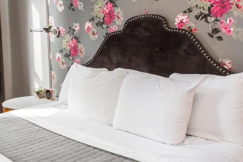 a bed with white pillows in a bedroom with flowers at Wicker Park Inn in Chicago