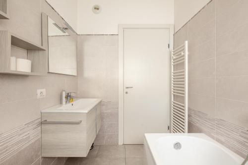 Luxury apartment with terrace - Forze Armate في ميلانو: حمام أبيض مع حوض ودش