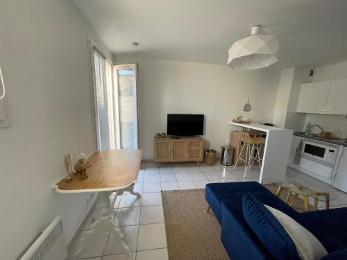 un salon avec une table et une cuisine dans l'établissement 2 pièces avec parking en Coeur de Ville - Appartement lumineux et calme, à La Rochelle