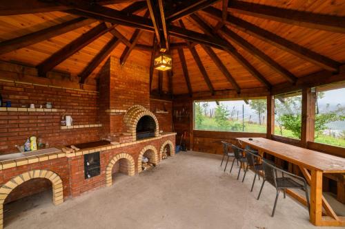 a dining room with a table and a brick oven at Chalet First Hill in Gura Humorului