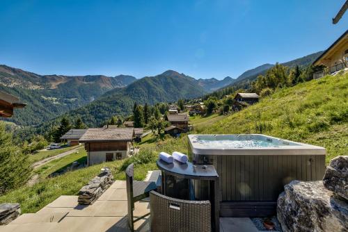 een hot tub op een heuvel met bergen op de achtergrond bij Chalet Bellevue in La Tzoumaz