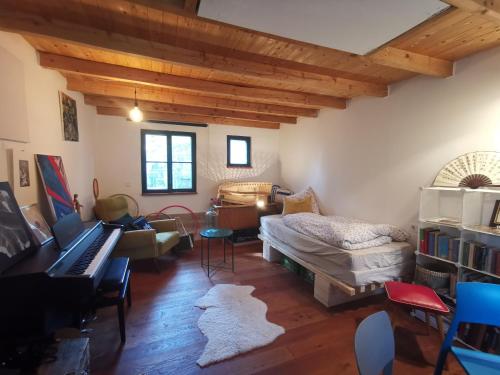 sala de estar con piano y dormitorio en Atelier & Gardenhouse Glamping en Múnich