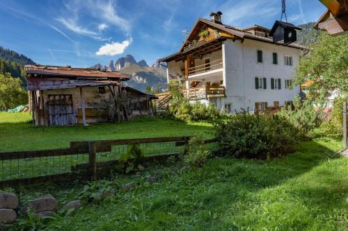 una casa in un campo vicino a una recinzione di Cesa Pecedel a Canazei