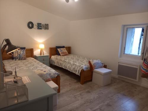 a small bedroom with two beds and a window at Le Quatorze in Bollène