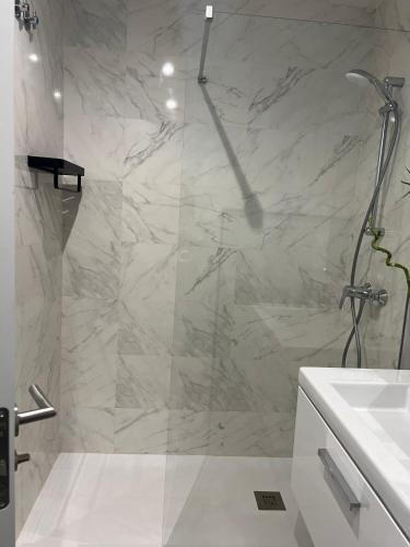 a white bathroom with a shower and a sink at SeaTorrox in Málaga