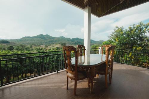 a table and chairs on a balcony with a view at Hakata Lejja near Natural Hot spring in Batu-Batu