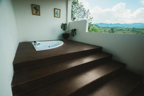 a bathroom with a sink and stairs with a window at Hakata Lejja near Natural Hot spring in Batu-Batu