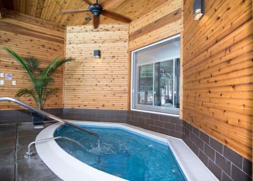 a hot tub in a room with a wooden wall at Villa Signor in Norwich