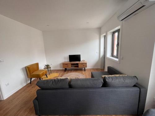 uma sala de estar com um sofá e uma televisão em Barros' House em Chaves