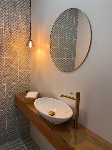 a bathroom with a sink and a mirror on a counter at Barros' House in Chaves