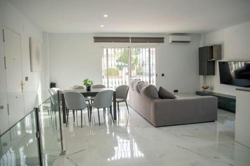 a living room with a couch and a table and chairs at Villa el Olivo in Alhaurín de la Torre