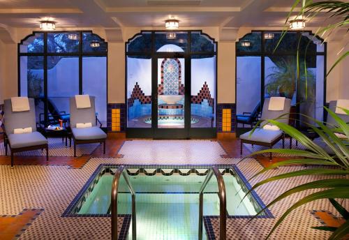 a room with a pool and chairs and a building at Ojai Valley Inn in Ojai