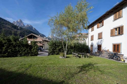 un patio con una mesa de picnic y un edificio en Cesa Meida 3, en Pozza di Fassa