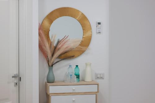 a mirror on top of a dresser with a vase at All'Uscita B&b in Eboli