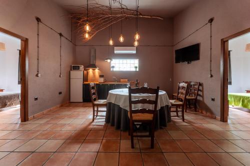 a dining room with a table and chairs and a kitchen at Bodega Andrés Iniesta con visita y cata in Fuentealbilla