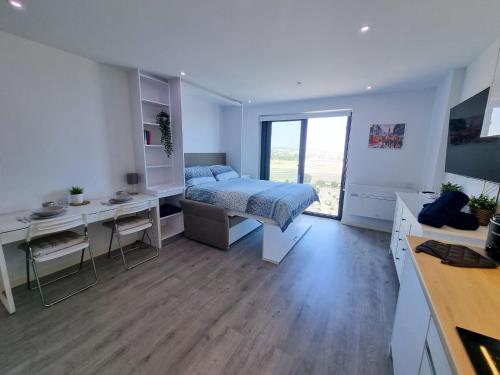 Brand New Top Floor Studio - The Hub Gibraltar - Self Catering في جبل طارق: غرفة نوم مع سرير ومكتب ومكتب