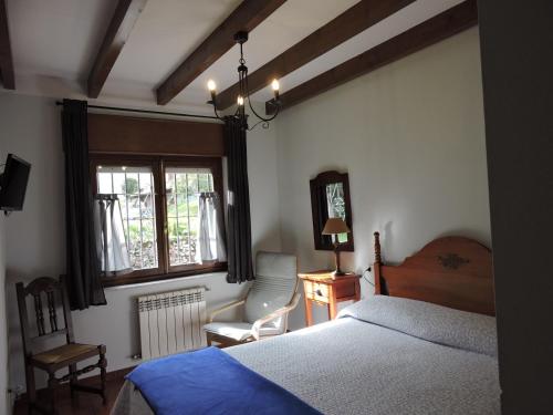 a bedroom with a bed and a chair and a window at Casa Pancho Porrúa in Porrúa