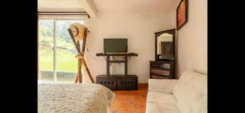 a bedroom with a bed and a mirror and a tv at Hotel Rancho el Paraíso in Valle de Bravo