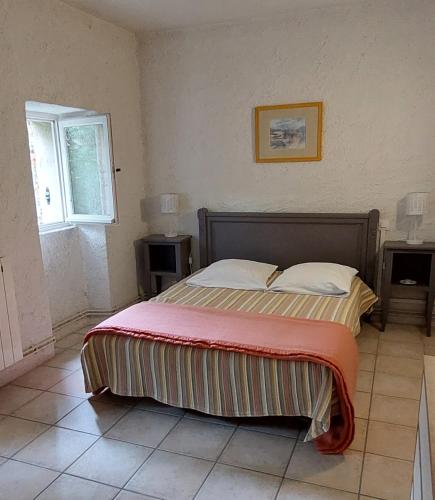 a bedroom with a bed with a red blanket on it at La Ginelle - Appartement Isba in Airoux