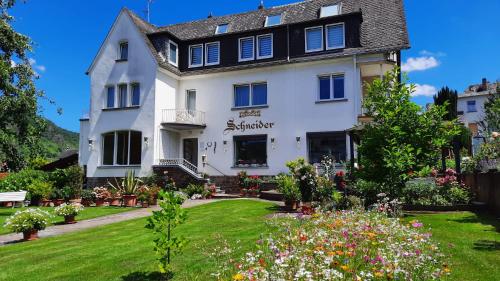 a white house with a garden in front of it at Pension Schneider in Cochem