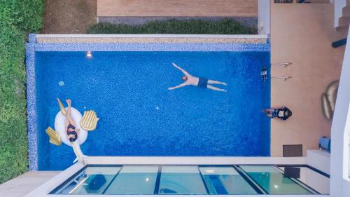 a person swimming in a swimming pool at Movenpick Pool Villa by Hello Pattaya in Na Jomtien