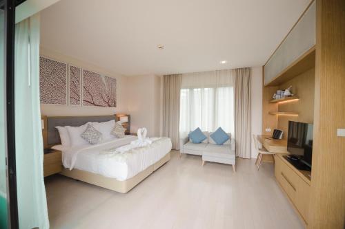 a bedroom with a bed and a desk and a television at Movenpick Pool Villa by Hello Pattaya in Na Jomtien