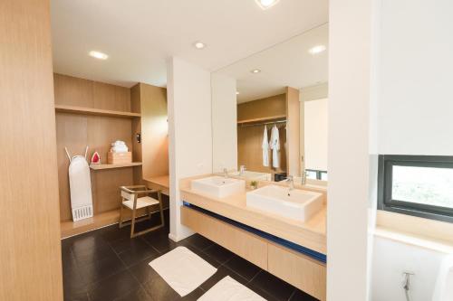 a bathroom with two sinks and a large mirror at Movenpick Pool Villa by Hello Pattaya in Na Jomtien