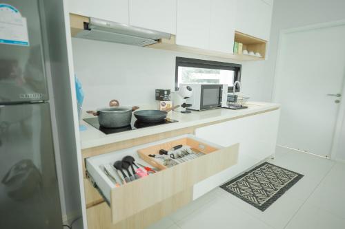 a kitchen with a counter with a drawer with utensils at Movenpick Pool Villa by Hello Pattaya in Na Jomtien
