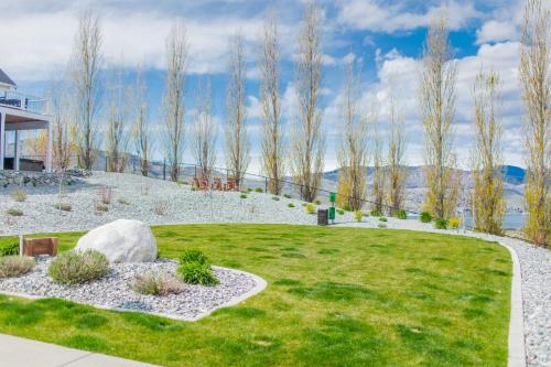 a garden with grass and rocks and trees at 5 O’Clock Somewhere #113 in Chelan