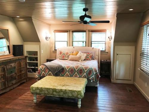 1 dormitorio con 1 cama y ventilador de techo en Farmhouse in a Peaceful Paradise with Huge Hot tub, en Gainesville