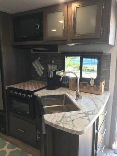 a kitchen with a sink and a stove at Happys Camper in the Sunshine in Daytona Beach