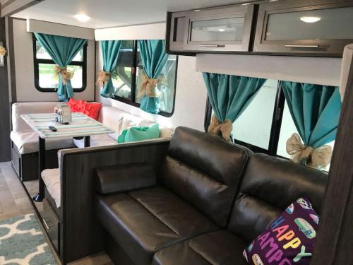a living room with a couch and a table at Happys Camper in the Sunshine in Daytona Beach