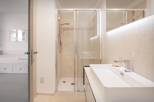 a white bathroom with a shower and a sink at Residenza Dimora Privata With Pool in Malcesine