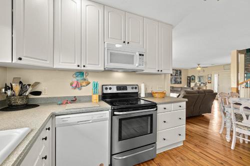 a kitchen with white cabinets and a stove top oven at Seaside Serenity Direct Oceanfront in Ormond Beach
