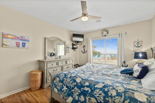 a bedroom with a bed and a window and a dresser at Seaside Serenity Direct Oceanfront in Ormond Beach