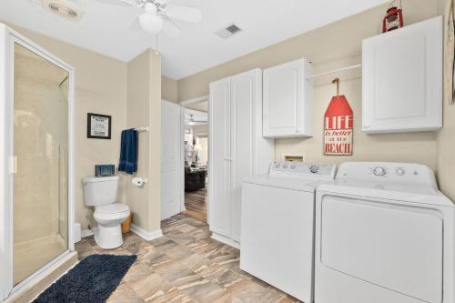 a white laundry room with a washer and dryer at Seaside Serenity Direct Oceanfront in Ormond Beach