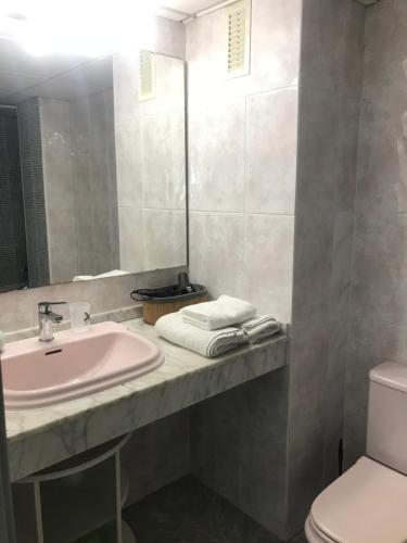 een badkamer met een wastafel, een toilet en een spiegel bij Perfect apartment near Port Aventura, beach in Salou