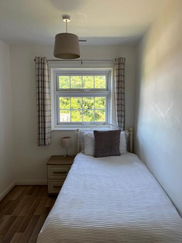 a bedroom with a bed and a window at Cosy Apartment in Wetheral,Cumbria in Wetheral