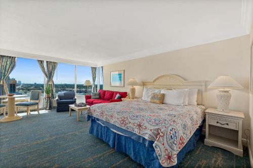 a hotel room with a bed and a living room at Sunshine Beach Condo with Balcony Pool Hot Tub in Daytona Beach