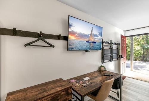 a dining room with a table and a tv on a wall at Candlewick Inn and Suites in Eureka Springs
