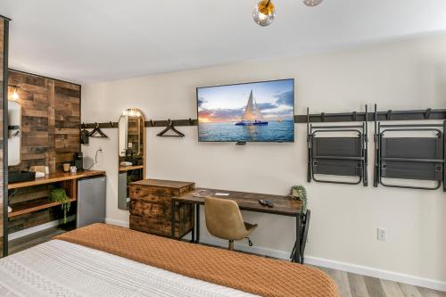 a bedroom with a desk and a sailboat on the wall at Candlewick Inn and Suites in Eureka Springs