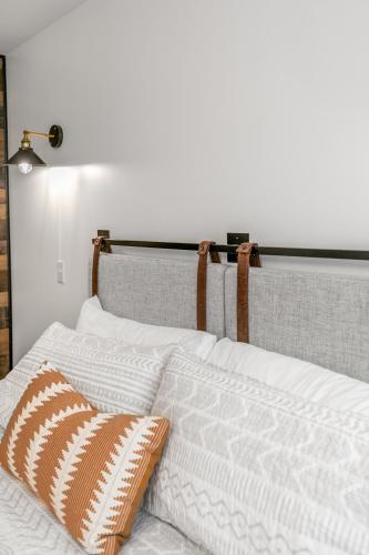 a bed with white blankets and pillows on it at Candlewick Inn and Suites in Eureka Springs