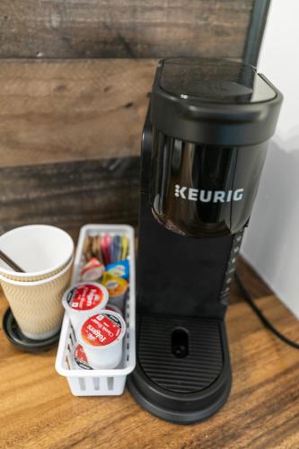 a black coffee maker sitting on a table with a container at Candlewick Inn and Suites in Eureka Springs