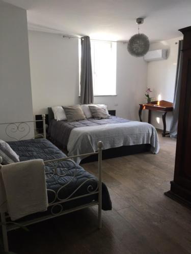 a bedroom with two beds and a chair and a window at Il Giardino dei Desideri in Viterbo