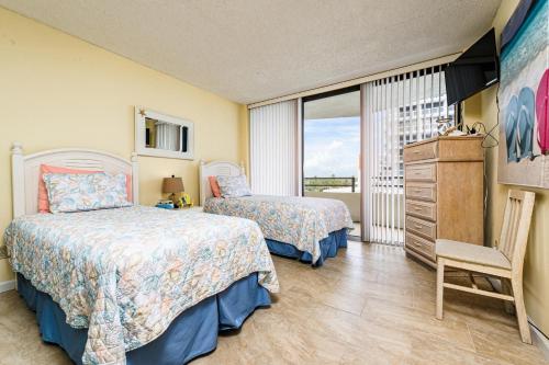 um quarto com 2 camas e uma cómoda e uma janela em Glorious Ocean Sunset Views 2 Bed 2 Bath Condo em Daytona Beach