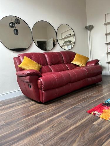 a red couch in a living room with two mirrors at Serenity in Longford