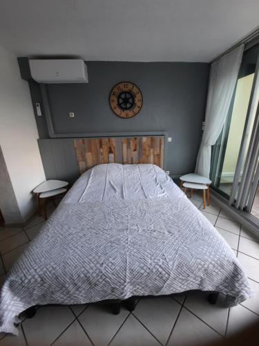 a bedroom with a bed with a clock on the wall at naturiste in Cap d'Agde