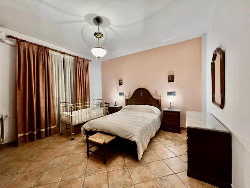 1 dormitorio con 1 cama y 1 silla en Casa Los Canos, en Úbeda